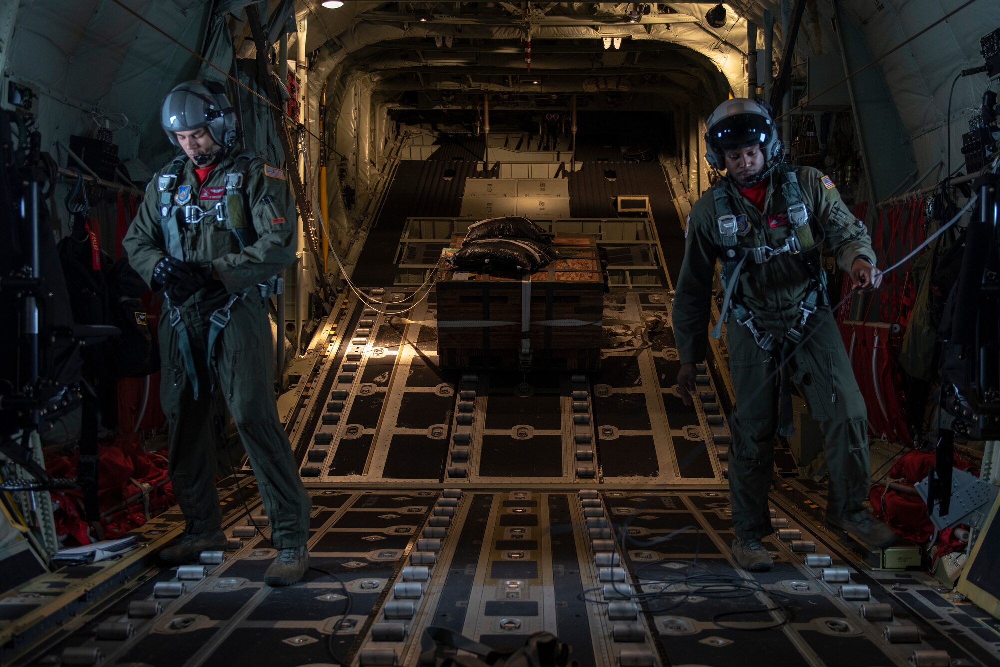 Staff Sgt. Brian Gates, left, and Staff Sgt. Ralph Colas, right, both 36th Airlift Squadron loadmasters, prepare to drop a bundle as part of a low-cost, low-altitude demonstration at the 2018 Japanese-American Friendship Festival at Yokota Air Base, Japan, Sept. 15, 2018.