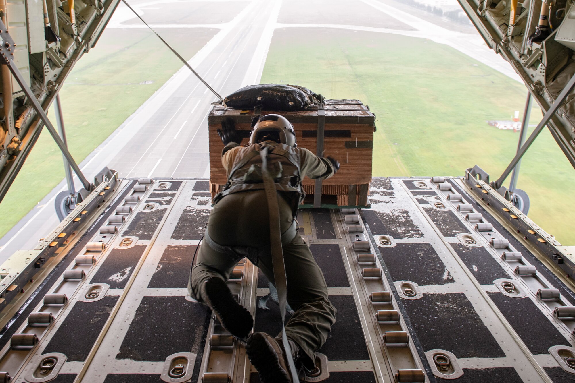 Staff Sgt. Ralph Colas, 36th Airlift Squadron loadmaster, pushes a bundle out of the back of a C-130J Super Hercules as part of a low-cost, low-altitude demonstration at the 2018 Japanese-American Friendship Festival at Yokota Air Base, Japan, Sept. 15, 2018.