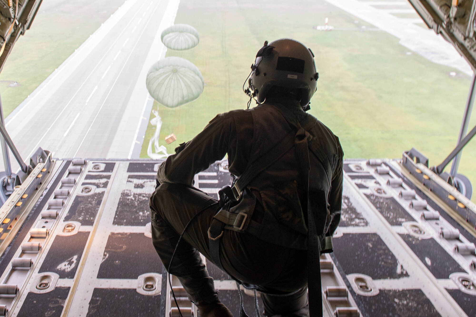 Staff Sgt. Ralph Colas, 36th Airlift Squadron loadmaster, looks out to verify the bundle being dropped successfully lands in the drop zone during a low-cost, low-altitude demonstration at the 2018 Japanese-American Friendship Festival at Yokota Air Base, Japan, Sept. 15, 2018.