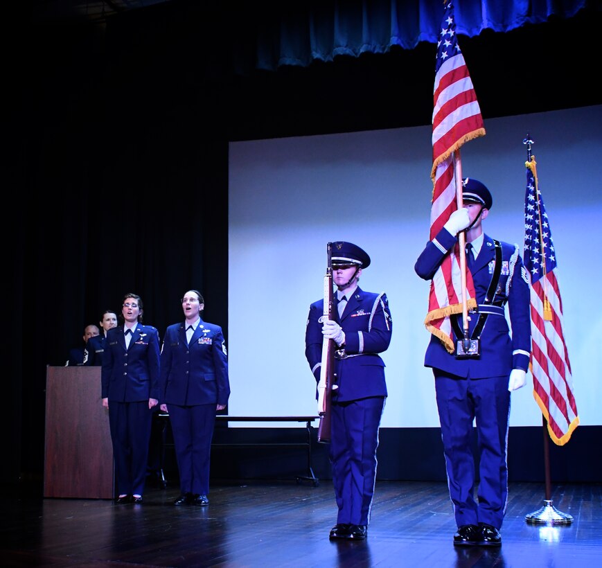 Singing the national anthem, "The Star Spangled Banner", 1st Lt. Rebecca Smith and Master Sgt. Karen Ridge help members of the 932nd Airlift Wing Honor Guard show respect for the American flag  at the start of the unit's Non-Commisioned and Senior Non-Commissioned Officer Induction Ceremony.  It was held as a special event during the 932nd AW's Unit Training Assembly, September 9, 2018, at Scott Air Force Base, Illinois.  Friends, family, and co-workers cheered as the new inductees walked up to collect their promotion certificates from the commander of the wing, Col. Raymond Smith, and the Command Chief, Chief Master Sgt. Barbara Gilmore.  The event recognized the leadership and skills of those members achieving higher ranks and leadership expectation status recently.  (U.S. Air Force photo by Lt. Col. Stan Paregien)