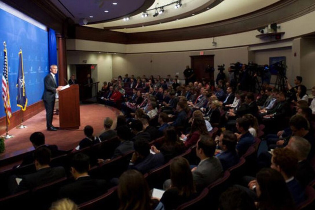 NATO Secretary General Jens Stoltenberg gives a speech from a stage.