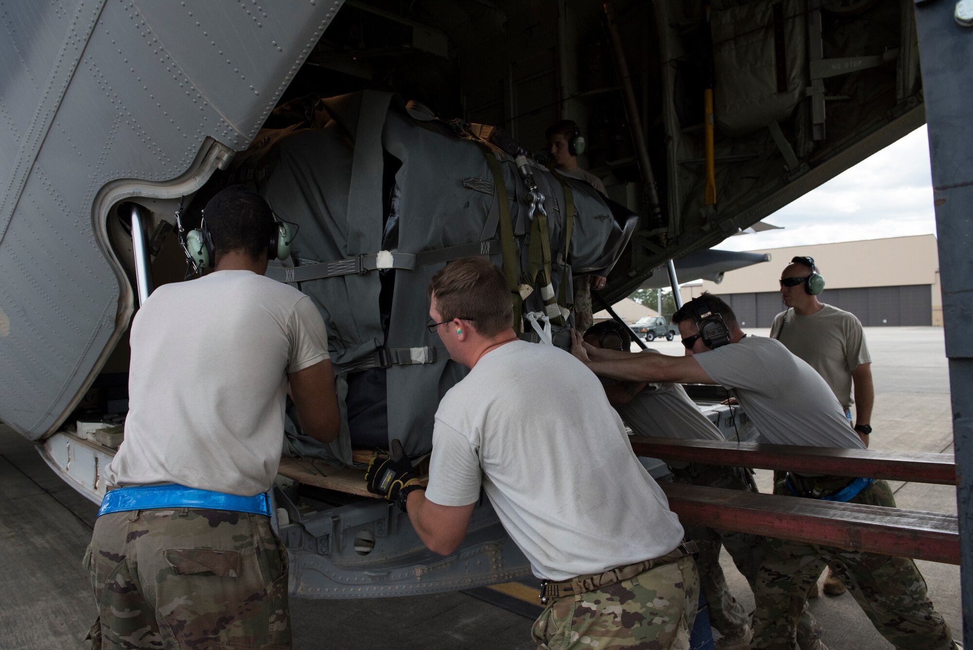 Airmen from the 71st Rescue Squadron and 723rd Aircraft Maintenance Squadron push a pallet onto a HC-130J Combat King II, Sept. 15, 2018, at Moody Air Force Base, Ga. The 334th Air Expeditionary Group launched HC-130J Combat King IIs, HH-60G Pavehawks, aircrew and support personnel to pre-position at Joint Base Charleston, S.C., for potential Tropical Storm Florence response. Under the command of Col. John Creel, the 374th Rescue Group commander, the AEG integrated to make one expeditionary search and rescue unit comprised of rescue and support personnel from both the 23d Wing, 920th Rescue Wing at Patrick Air Force Base, Fla., and 51st Communications Squadron at Warner Robins Air Force Base, Ga.  (U.S. Air Force photo by Staff Sgt. Eric Summers Jr.)