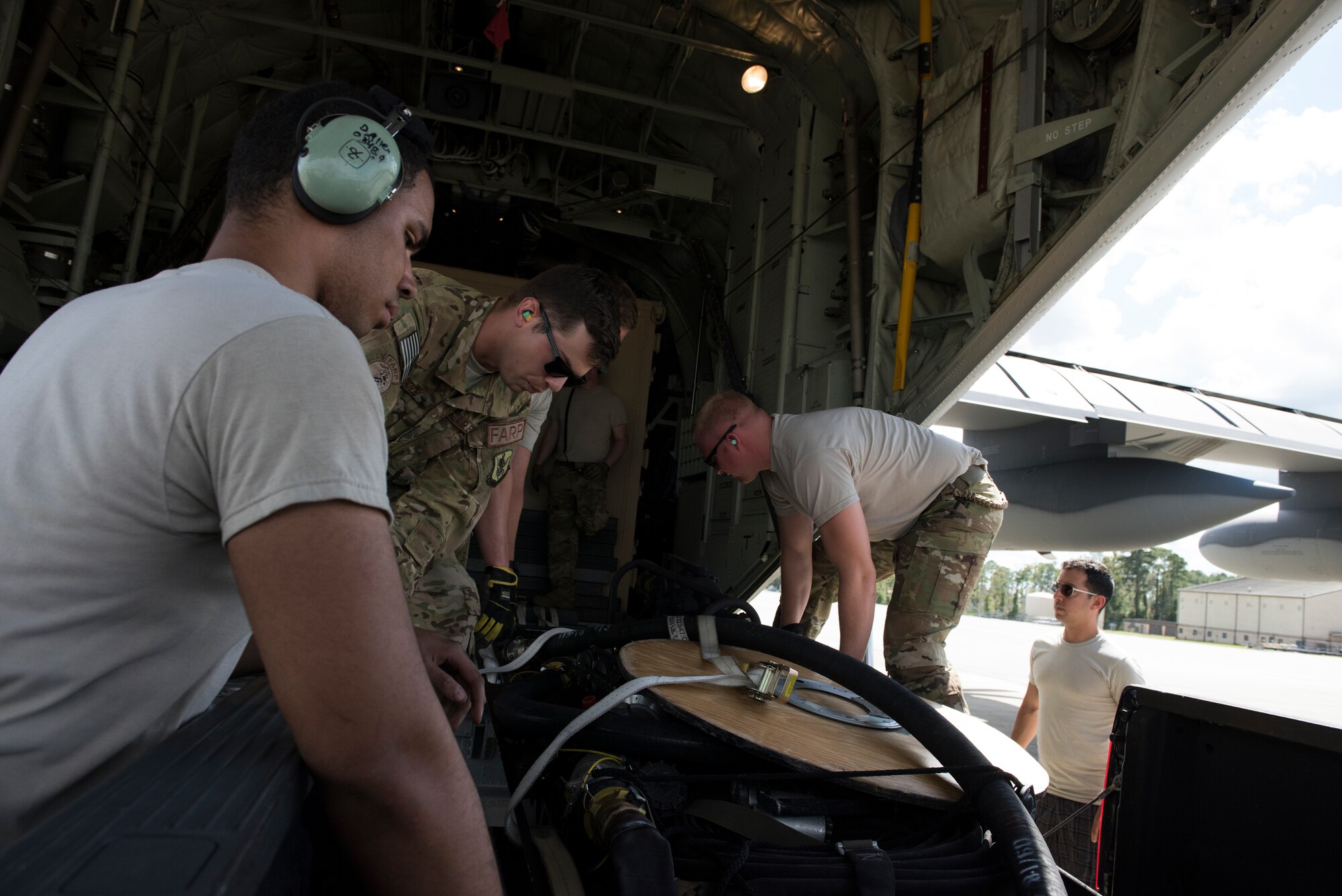Airmen from the 71st Rescue Squadron and 723rd Aircraft Maintenance Squadron slide equipment onto a HC-130J Combat King II, Sept. 15, 2018, at Moody Air Force Base, Ga. The 334th Air Expeditionary Group launched HC-130J Combat King IIs, HH-60G Pavehawks, aircrew and support personnel to pre-position at Joint Base Charleston, S.C., for potential Tropical Storm Florence response. Under the command of Col. John Creel, the 374th Rescue Group commander, the AEG integrated to make one expeditionary search and rescue unit comprised of rescue and support personnel from both the 23d Wing, 920th Rescue Wing at Patrick Air Force Base, Fla., and 51st Communications Squadron at Warner Robins Air Force Base, Ga.  (U.S. Air Force photo by Staff Sgt. Eric Summers Jr.)