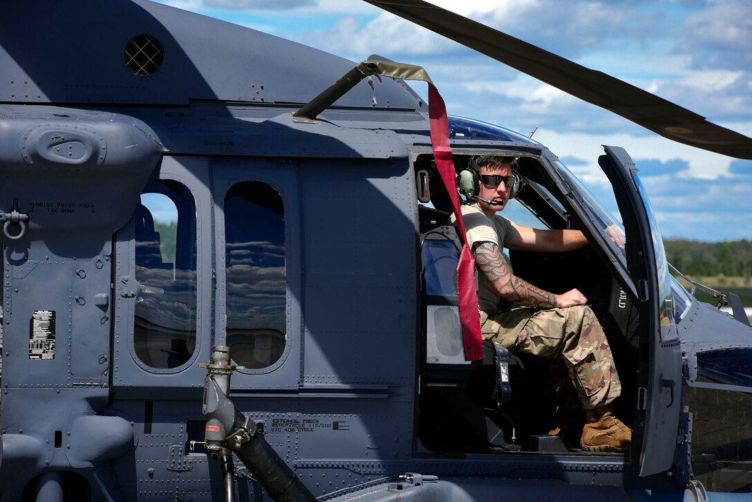 An Airman from the 41st Helicopter Maintenance Unit sits in an HH-60G Pavehawk helicopter, Sept. 15, 2018, at Moody Air Force Base, Ga. The 334th Air Expeditionary Group launched HC-130J Combat King IIs, HH-60G Pavehawks, aircrew and support personnel to pre-position at Joint Base Charleston, S.C., for potential Tropical Storm Florence response. Under the command of Col. John Creel, the 374th Rescue Group commander, the AEG integrated to make one expeditionary search and rescue unit comprised of rescue and support personnel from both the 23d Wing, 920th Rescue Wing at Patrick Air Force Base, Fla., and 51st Combat Communications Squadron at Robins Air Force Base, Ga. (U.S. Air Force photo by Senior Airman Greg Nash)