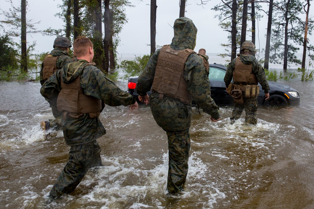Marines with Marine Corps Base Camp Lejeune help push a car out of a flooded area during Hurricane Florence, on Marine Corps Base Camp Lejeune, Sept. 15, 2018. Hurricane Florence impacted MCB Camp Lejeune and Marine Corps Air Station New River with periods of strong winds, heavy rains, flooding of urban and low lying areas, flash floods and coastal storm surges.