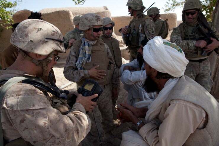 U.S. Marine Corps Staff Sgt. Paul Rogers, a team leader with Georgian Liaison Team 9, uses a Secure Electronic Enrollment Kit (SEEK II) on patrol in Mohammad Abad, Helmand province, Afghanistan, July 23, 2013.