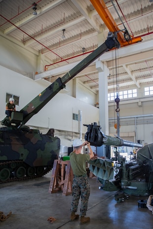Lance Cpl. Dario Covarrubias and Lance Cpl. Sidney Vanderhook position a cannon tube during the reassembly of a M777 A2 Medium Towed Howitzer Sept. 14, 2018, at Camp Hansen, Okinawa, Japan. Armament Repair Platoon repairs weapons in support of 3rd Battalion, 12th Marine Regiment, 3rd Marine Division to ensure the safety of the Marines operating the weapons. Vanderhook is an artillery mechanic with Armament Repair Platoon, Ordnance Maintenance Company, 3rd Maintenance Battalion, Combat Logistics Regiment 35, 3rd Marine Logistics Group, and is a native of Southaven, Mississippi. Covarrubias is an Amphibious Assault Vehicle mechanic with Armament Repair Platoon, Ordnance Maintenance Co. and is a native of Chicago, Illinois. (U.S. Marine Corps photo by Pfc. Terry Wong)