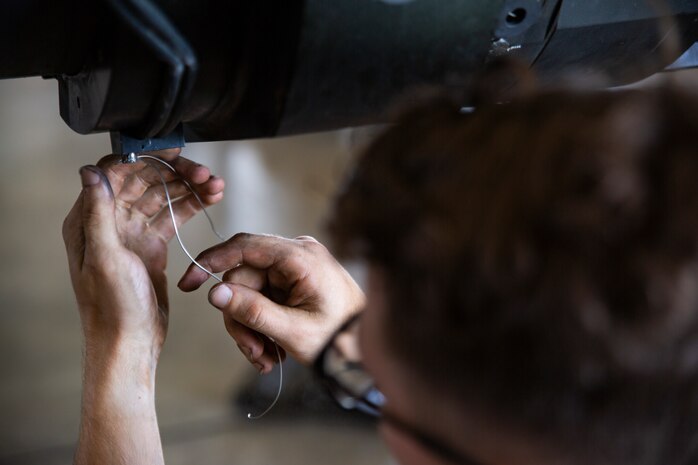 Cpl. Salvatore Ferrigno passes a metal wire through a bolt during the reassembly of a M777 A2 Medium Towed Howitzer Sept. 14, 2018, at Camp Hansen, Okinawa, Japan. Armament Repair Platoon repairs weapons in support of 3rd Battalion, 12th Marine Regiment, 3rd Marine Division to ensure the safety of the Marines operating the weapons. Ferrigno is a machinist with Armament Repair Platoon, Ordnance Maintenance Company, 3rd Maintenance Battalion, Combat Logistics Regiment 35, 3rd Marine Logistics Group, and is a native of Barnegat, New Jersey. (U.S. Marine Corps photo by Pfc. Terry Wong)