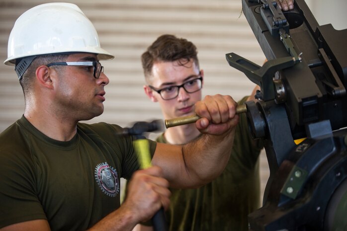 Lance Cpl. Dario Covarrubias hammers a part into place during the reassembly of a M777 A2 Medium Towed Howitzer Sept. 14, 2018, at Camp Hansen, Okinawa, Japan. Armament Repair Platoon repairs weapons in support of 3rd Battalion, 12th Marine Regiment, 3rd Marine Division to ensure the safety of the Marines operating the weapons. Covarrubias is an Amphibious Assault Vehicle mechanic with Armament Repair Platoon, Ordnance Maintenance Company, 3rd Maintenance Battalion, Combat Logistics Regiment 35, 3rd Marine Logistics Group, and is a native of Chicago, Illinois. (U.S. Marine Corps photo by Pfc. Terry Wong)