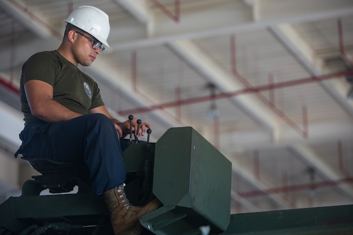 Lance Cpl. Dario Covarrubias operates the crane of an Amphibious Assault Vehicle R7 during the reassembly of a M777 A2 Medium Towed Howitzer Sept. 14, 2018, at Camp Hansen, Okinawa, Japan. Armament Repair Platoon repairs weapons in support of 3rd Battalion, 12th Marine Regiment, 3rd Marine Division to ensure the safety of the Marines operating the weapons. Covarrubias is an AAV mechanic with Armament Repair Platoon, Ordnance Maintenance Company, 3rd Maintenance Battalion, Combat Logistics Regiment 35, 3rd Marine Logistics Group, and is a native of Chicago, Illinois. (U.S. Marine Corps photo by Pfc. Terry Wong)