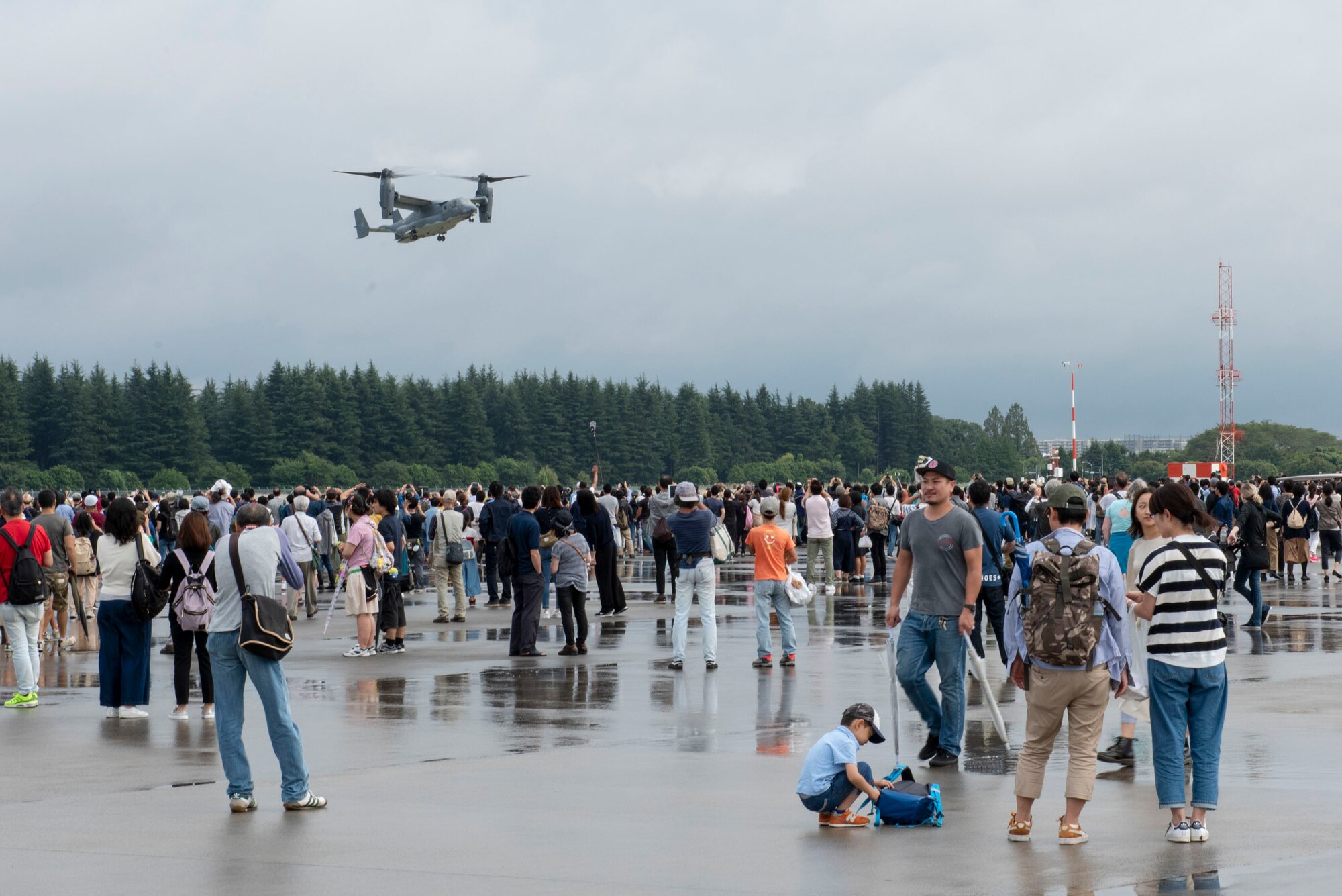 Festivalgoers look on as a CV-22 Osprey performs at the 2018 Japanese-American Friendship Festival at Yokota Air Base, Japan, Sept. 15, 2018.
