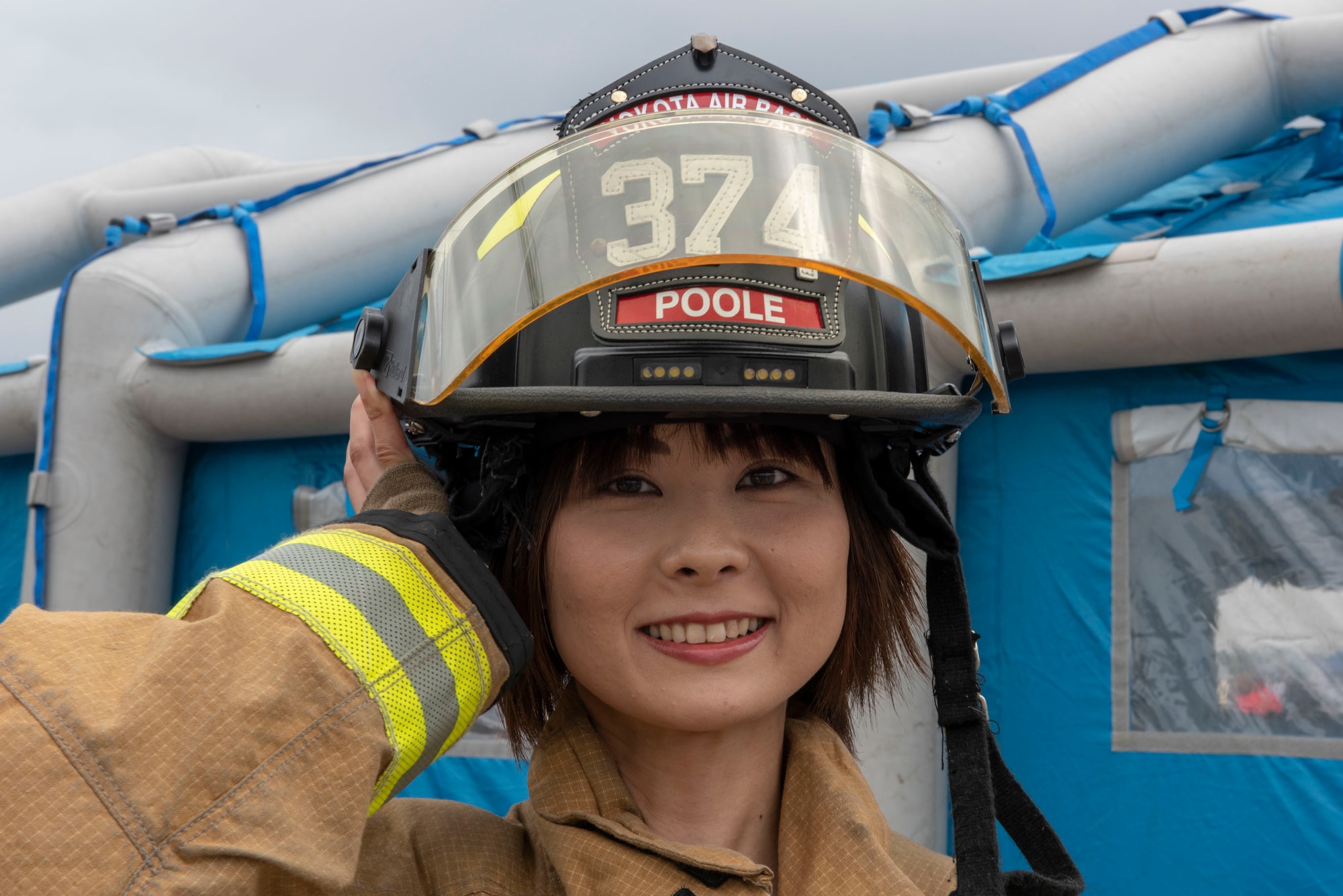 A festivalgoer tries on the equipment of the 374th Civil Engineering Squadron firefighters at the 2018 Japanese-American Friendship Festival at Yokota Air Base, Japan, Sept. 16, 2018.