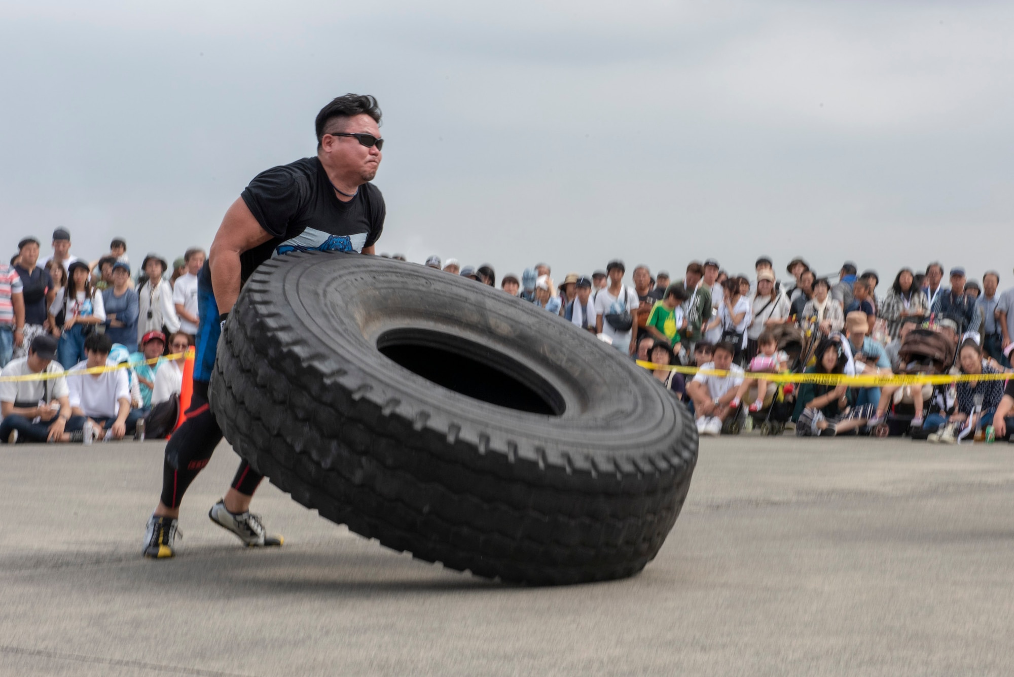 A competitor in the 2018 Japanese-American Friendship Festival Strong Man competition lifts and flips a tire at Yokota Air Base, Japan, Sept. 16, 2018.