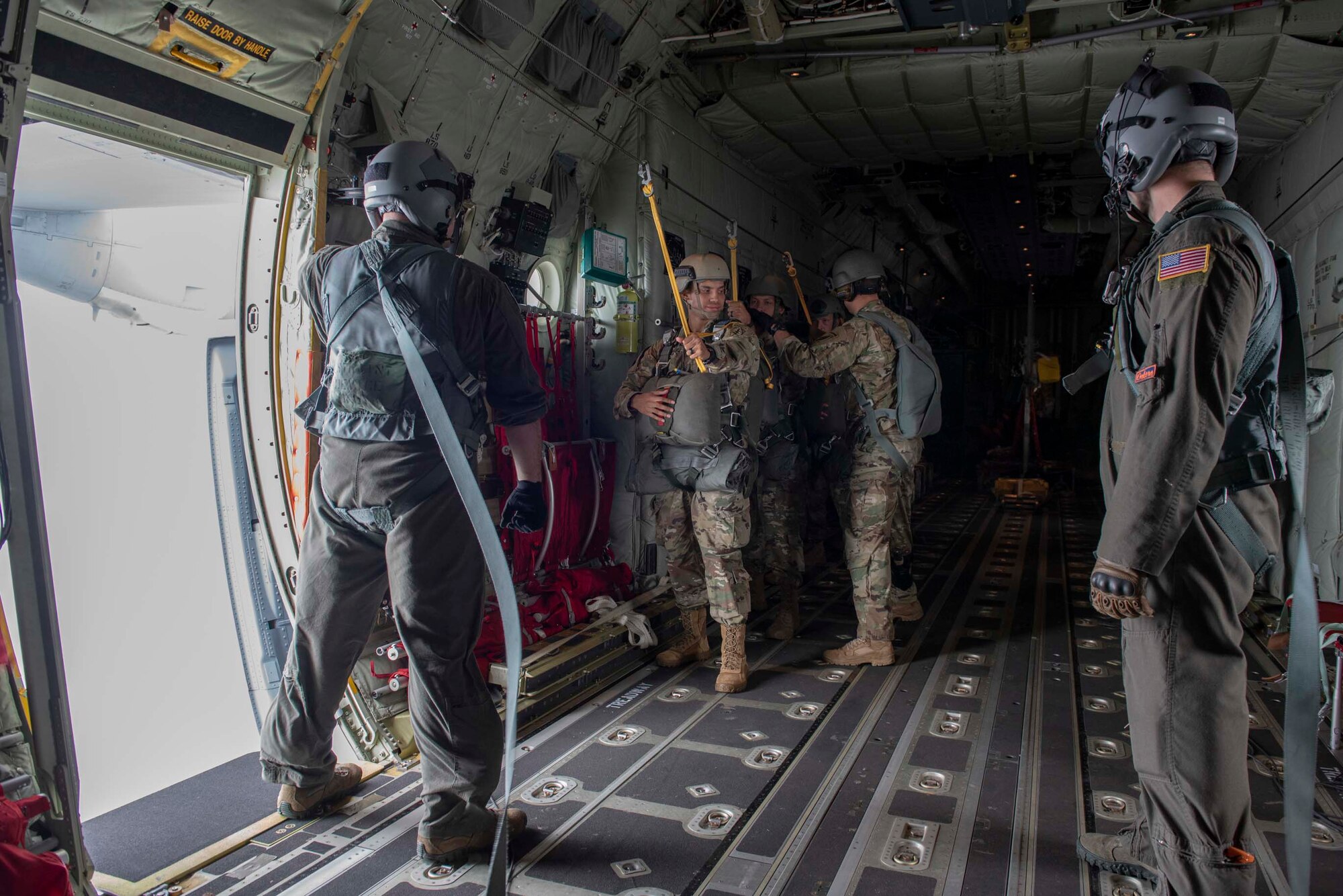 Staff Sgt. Zach Barnes, left, 36th Airlift Squadron loadmaster, stands by as members of the U.S. Army 1st Special Forces Group receive final instructions prior to performing a static line jump demonstration at the 2018 Japanese-American Friendship Festival at Yokota Air Base, Japan, Sept. 16, 2018.