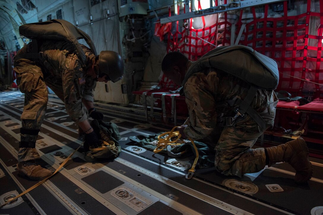 U.S. Army 1st Lt. Nicholas Bonavia, left, 1st Special Forces Group jumpmaster, and Sgt. Aaron Agee, right, 1st SFG combat cameraman, perform post jump procedures after a static line jump demonstration at the 2018 Japanese-American Friendship Festival at Yokota Air Base, Japan, Sept. 16, 2018.