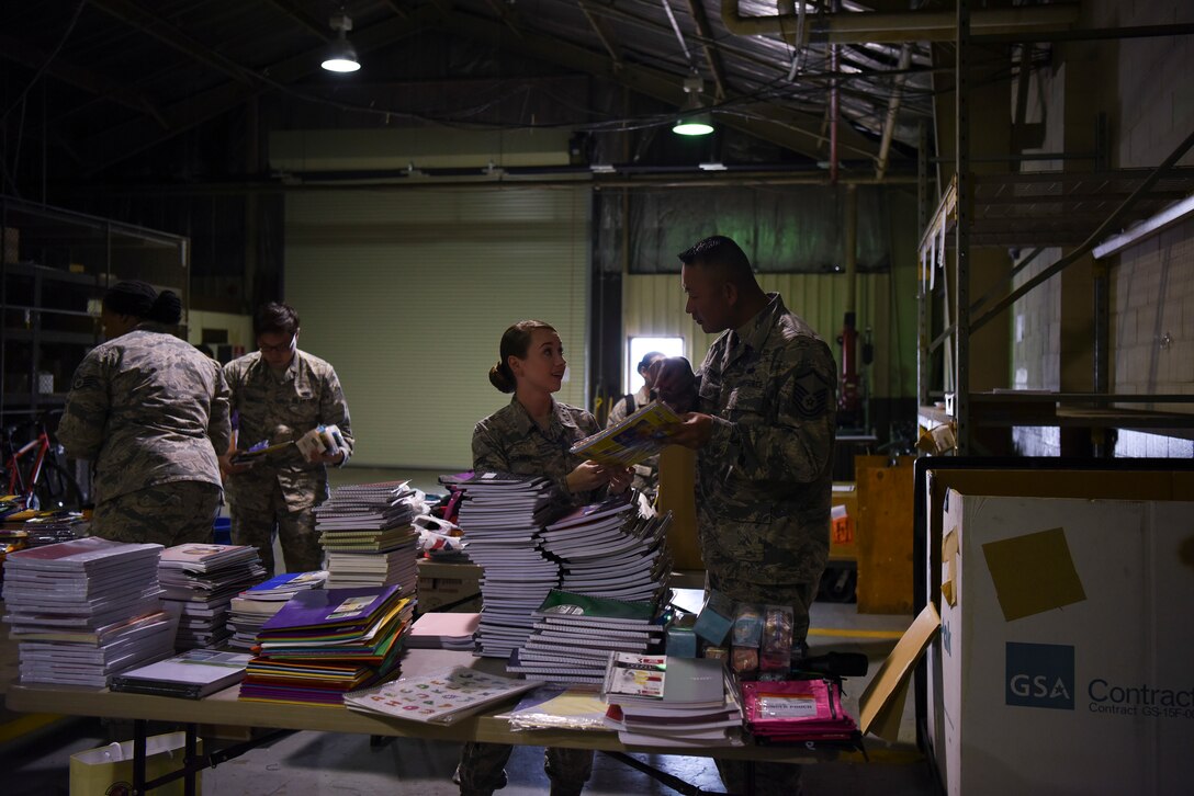 U.S. Air Force Airman 1st Class Katherine Bruner (left), 8th Logistics Readiness Squadron individual protective equipment technician, and Master Sgt. David Goater (right), 8th LRS maintenance support section chief, sort through donations collected during a Back to School Drive at Kunsan Air Base, Republic of Korea, Sept. 13, 2018. The Back to School Drive received over 500 supplies for local schools. (U.S. Air Force photo by Senior Airman Savannah L. Waters)
