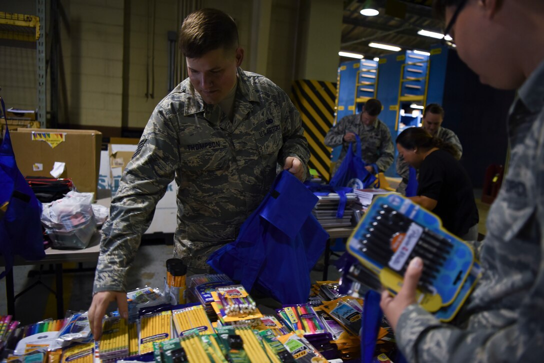 U.S. Air Force Tech. Sgt. Dustin Thompson, 8th Logistics Readiness Squadron inspection and inventory noncommissioned officer in charge, packs school supplies into a bag at Kunsan Air Base, Republic of Korea, Sept. 13, 2018. The Back to School Drives received over 500 donations including notebooks, writing utensils, erasers, books, backpacks, and other supplies to give to local schools. (U.S. Air Force photo by Senior Airman Savannah L. Waters)