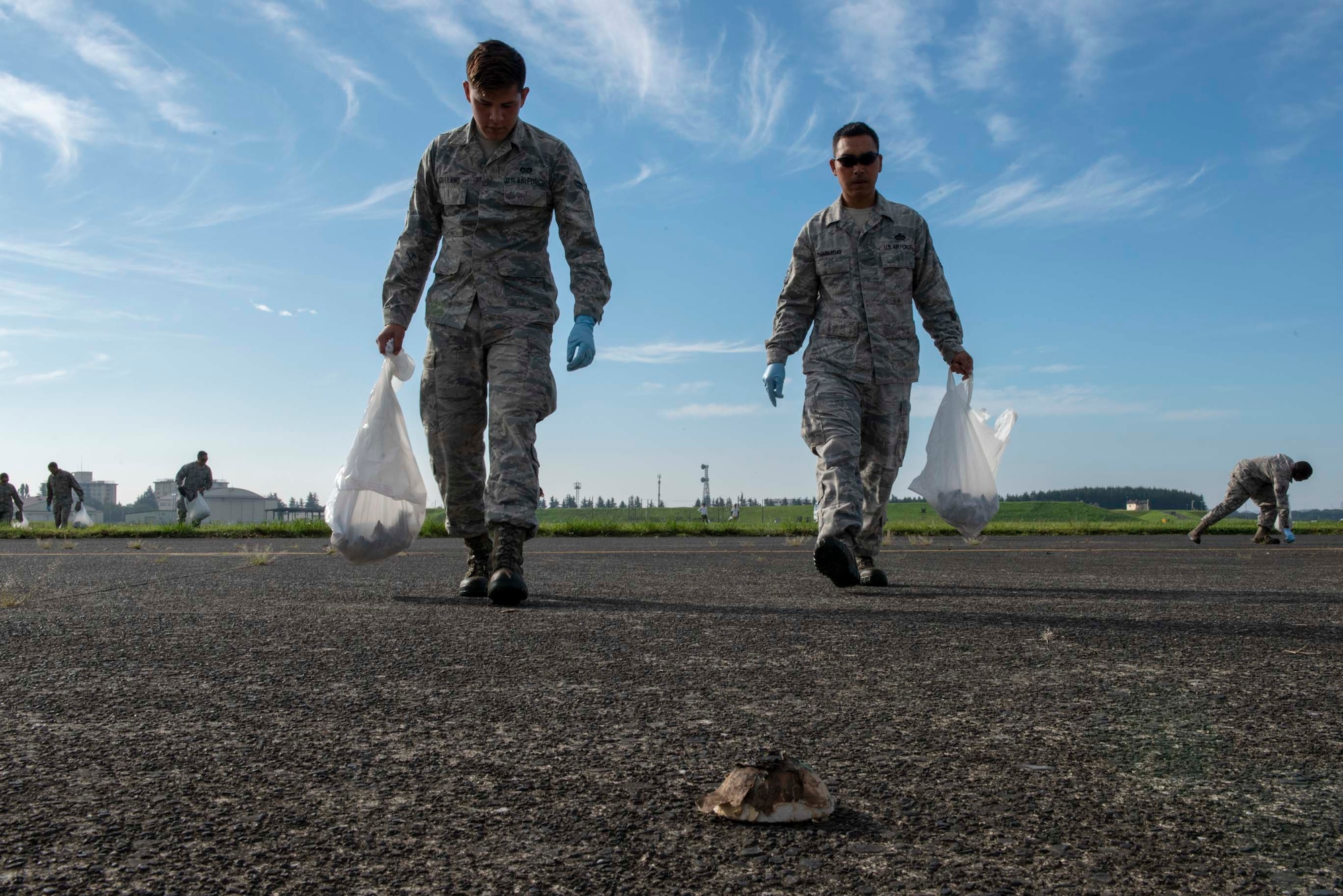 Airmen from the 374th Airlift Wing search the flightline for debris during a foreign object debris walk following the 2018 Japanese-American Friendship Festival at Yokota Air Base, Japan, Sept. 17, 2018.