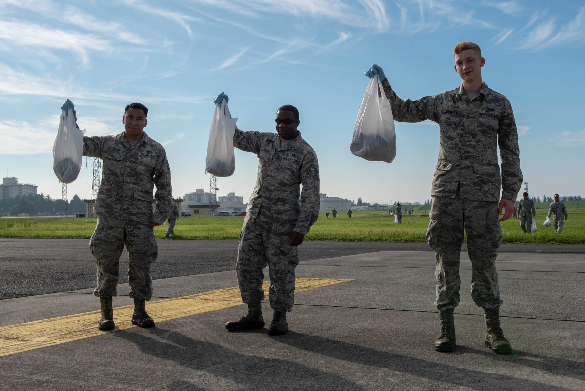 Airmen from the 374th Airlift Wing pose for a photo showcasing their pickup during the foreign object debris walk following the 2018 Japanese-American Friendship Festival at Yokota Air Base, Japan, Sept. 17, 2018.