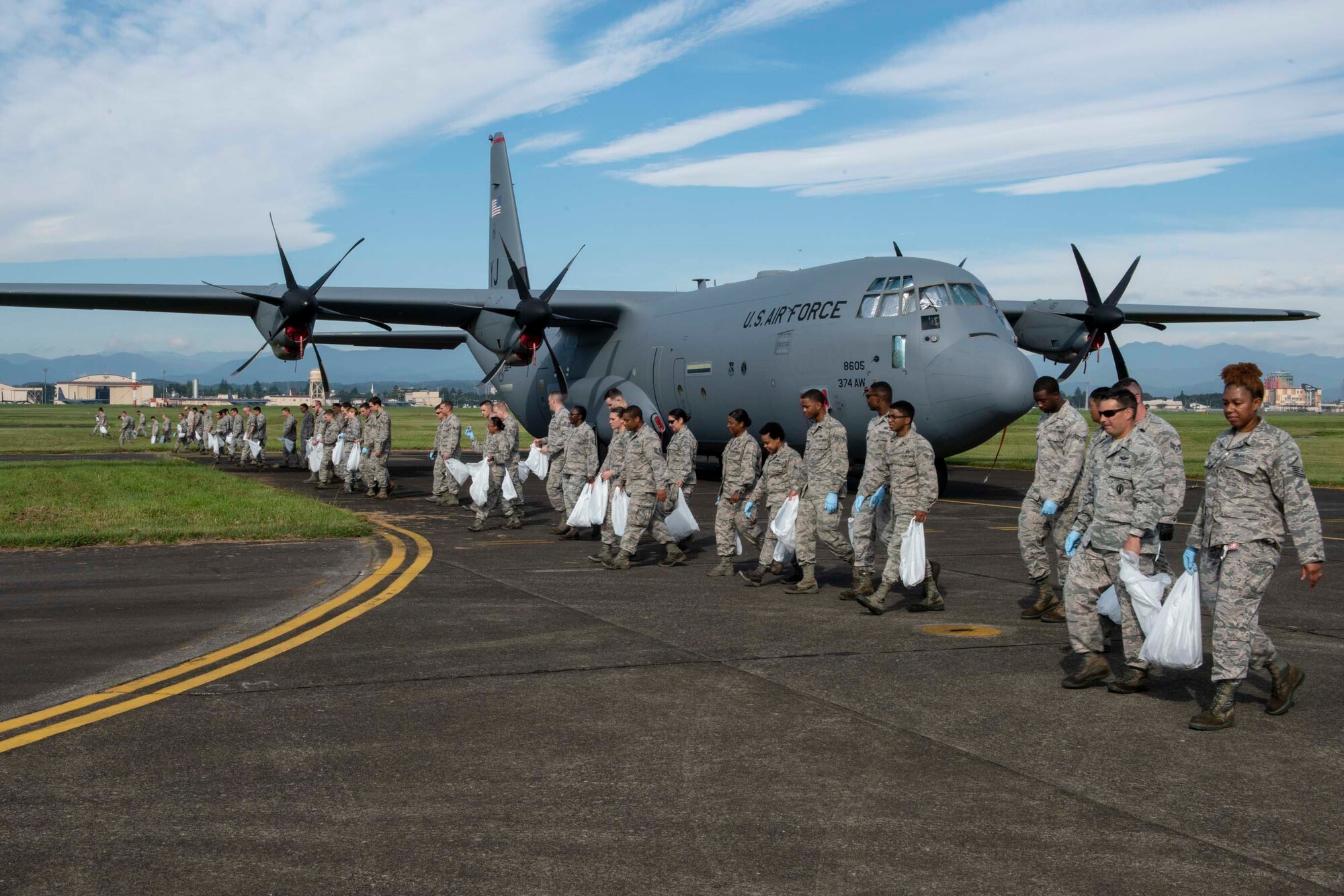 The Airmen from the 374th Airlift Wing perform a foreign object debris walk following the 2018 Japanese-American Friendship Festival at Yokota Air Base, Japan, Sept. 17, 2018.
