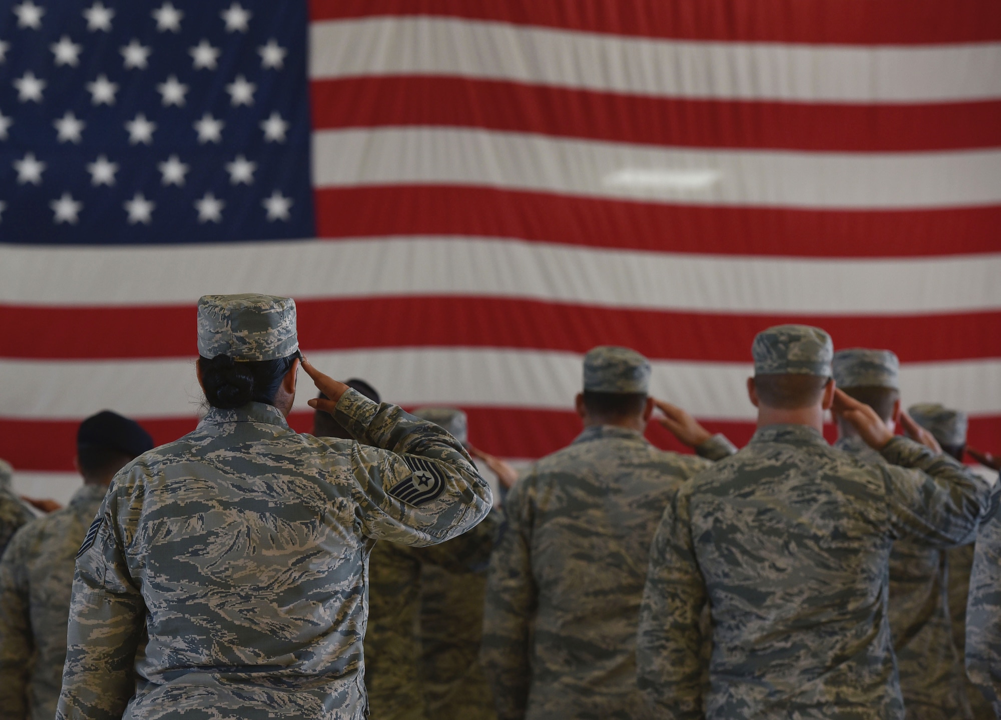 U.S. Air Force Airmen stand and salute the flag during the singing of the national anthem at a 9/11 remembrance ceremony in Hangar 5 at Tyndall Air Force Base, Fla., Sept. 11, 2018. The ceremony started at the exact moment the first tower was hit to honor the people who died Sept. 11, 2001. (U.S. Air Force photo by Airman 1st Class Miranda M.B. Simpson)