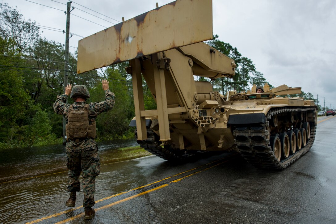 U.S. Marine Corps Cpl. Tyler J. Sheldon, left, combat engineer, Mobility Assault Company, 2nd Combat Engineer Battalion, 2nd Marine Division, directs the driver of an armored vehicle launch bridge after Hurricane Florence on Marine Corps Base Camp Lejeune, Sept. 16, 2018. Hurricane Florence impacted MCB Camp Lejeune and Marine Corps Air Station New River with periods of strong winds, heavy rains, flooding of urban and low lying areas, flash floods and coastal storm surges. (U.S. Marine Corps Photo by Lance Cpl. Isaiah Gomez)