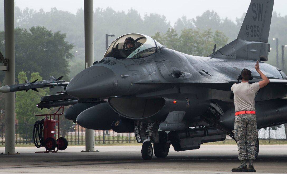 A 20th Aircraft Maintenance Squadron tactical aircraft maintainer marshals an F-16CM Fighting Falcon at Shaw Air Force Base, S.C., Sept. 12, 2018.