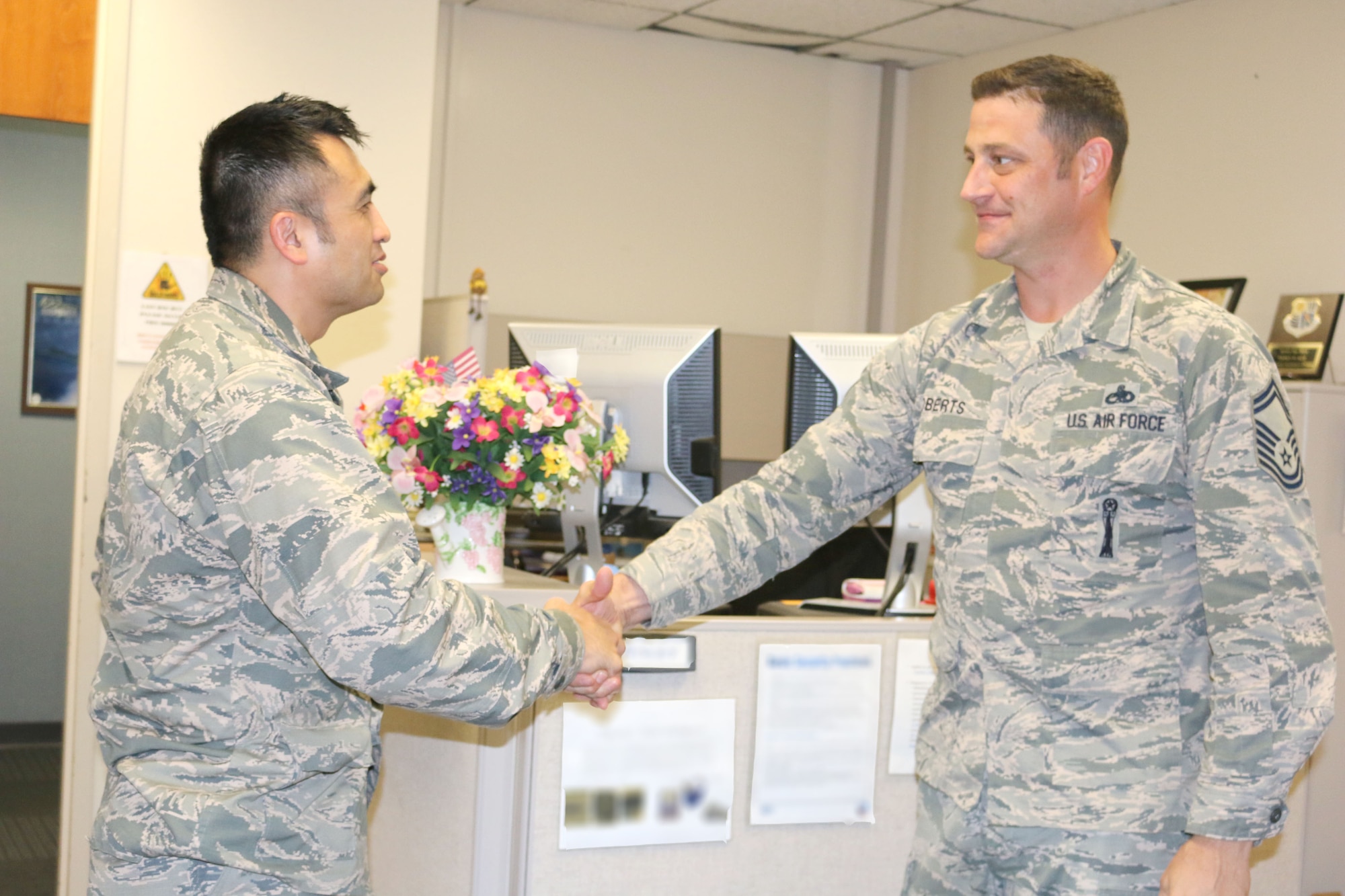 Col. John Tran (left), AEDC Test Systems Sustainment Chief, speaks to Senior Master Sgt. Michael Roberts in the TSS Office at Arnold AFB. (U.S. Air Force photo by Deidre Ortiz) (This image was manipulated by obscuring items for security purposes)