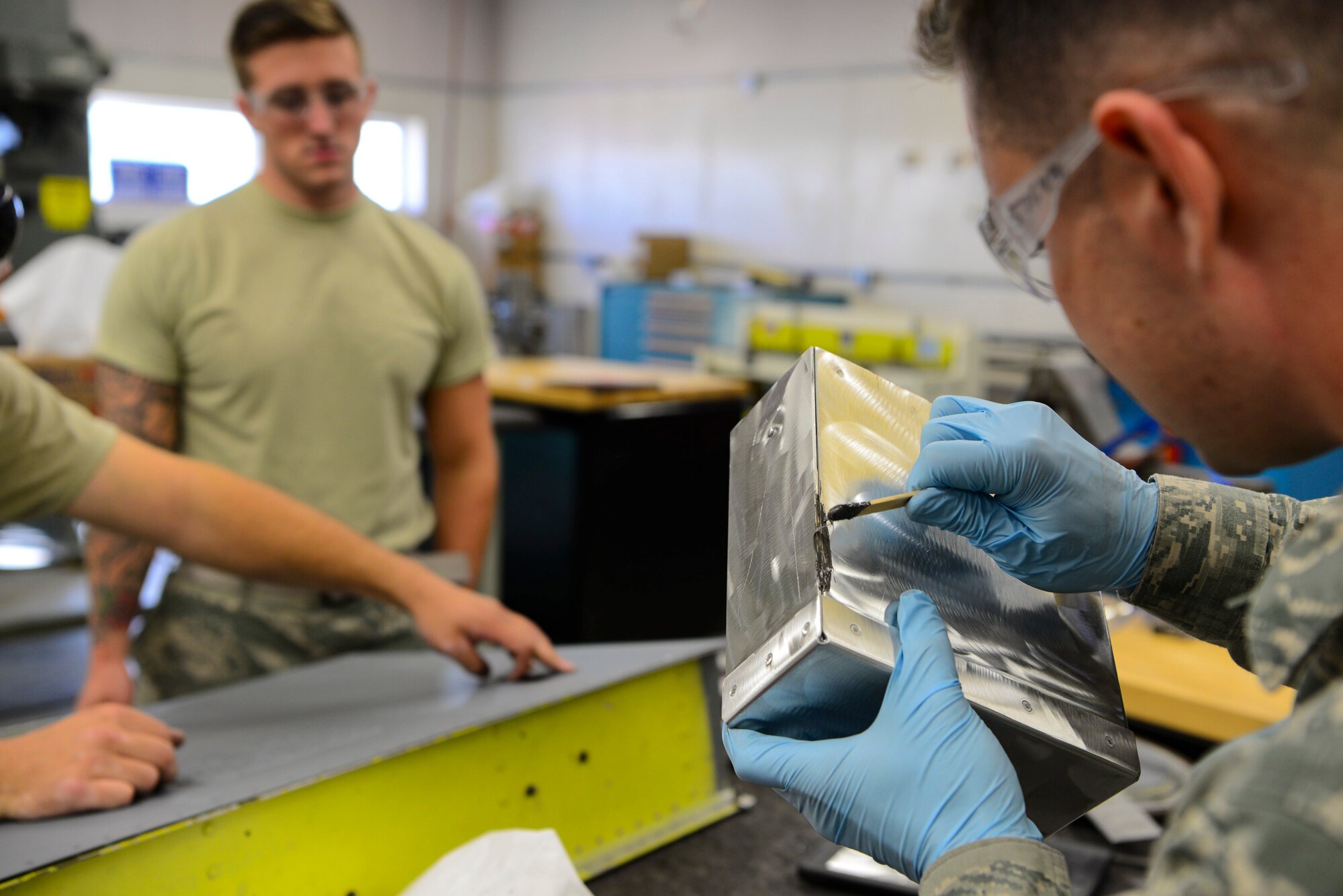 U.S. Air Force Airmen from the 168th Aircraft Maintenance Squadron, assesses damage on an aircraft part Sept. 7, 2018, on Eielson Air Force Base, Alaska. Aircraft structural mechanics modify and alter aircraft parts according to the desired engineering specifications.(U.S. Air Force photo by Airman Aaron Guerrisky)