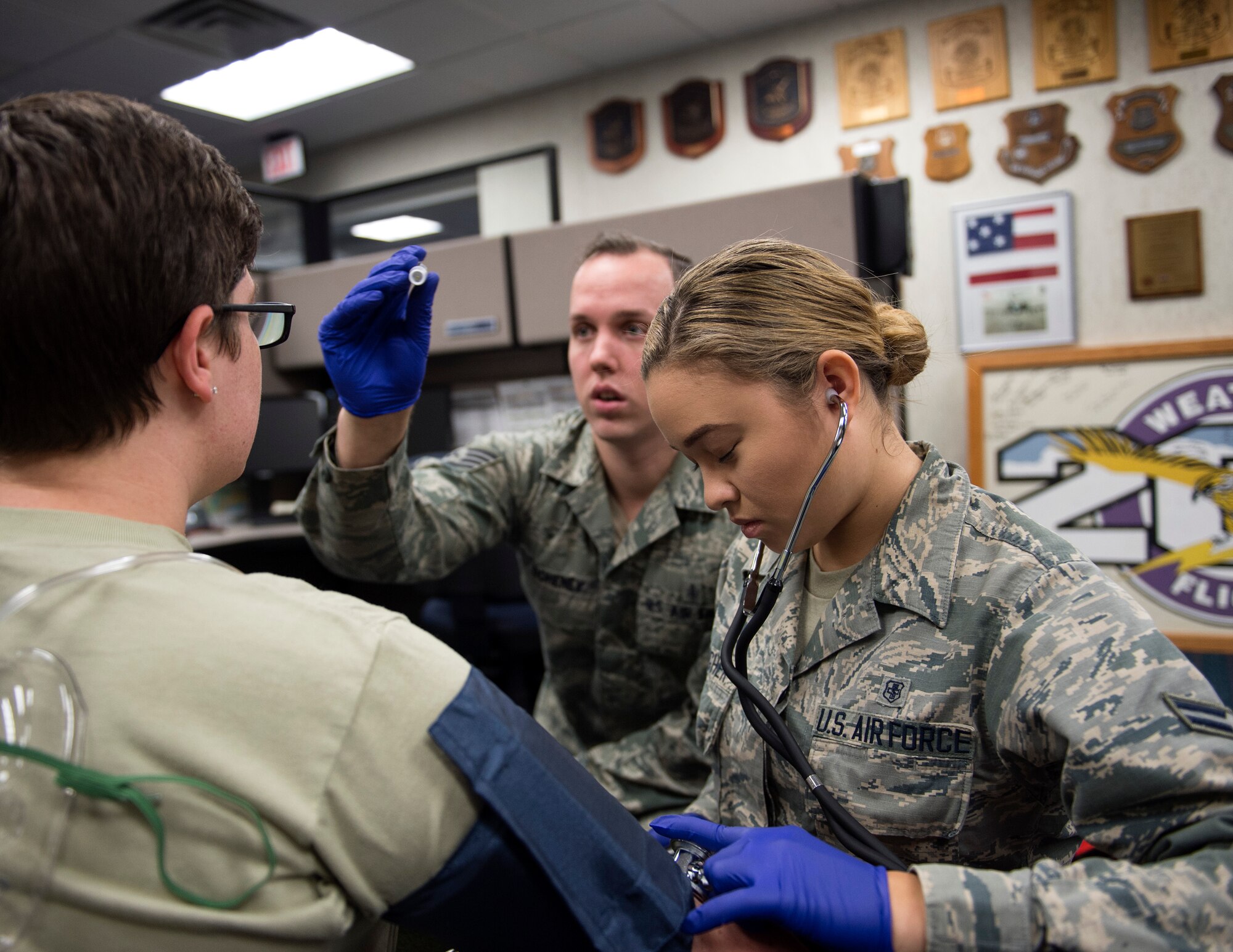 U.S. Air Force Airman 1st Class Angela Gallagher, right, and Staff Sgt. Patrick Doheney, emergency medical technicians, check the vitals of a role-player in St. Paul, Minn., Aug. 17, 2018.