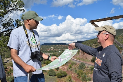 Senior Advisor to the Army National Guard U.S. Army Lt. Col. Shannon Espinoza, left, and Chief Warrant Officer 4 John Mudlo, right, a Colorado Army National Guard Soldier, discuss key aspects of the Apache Canyon terrain during the Colorado National Guard