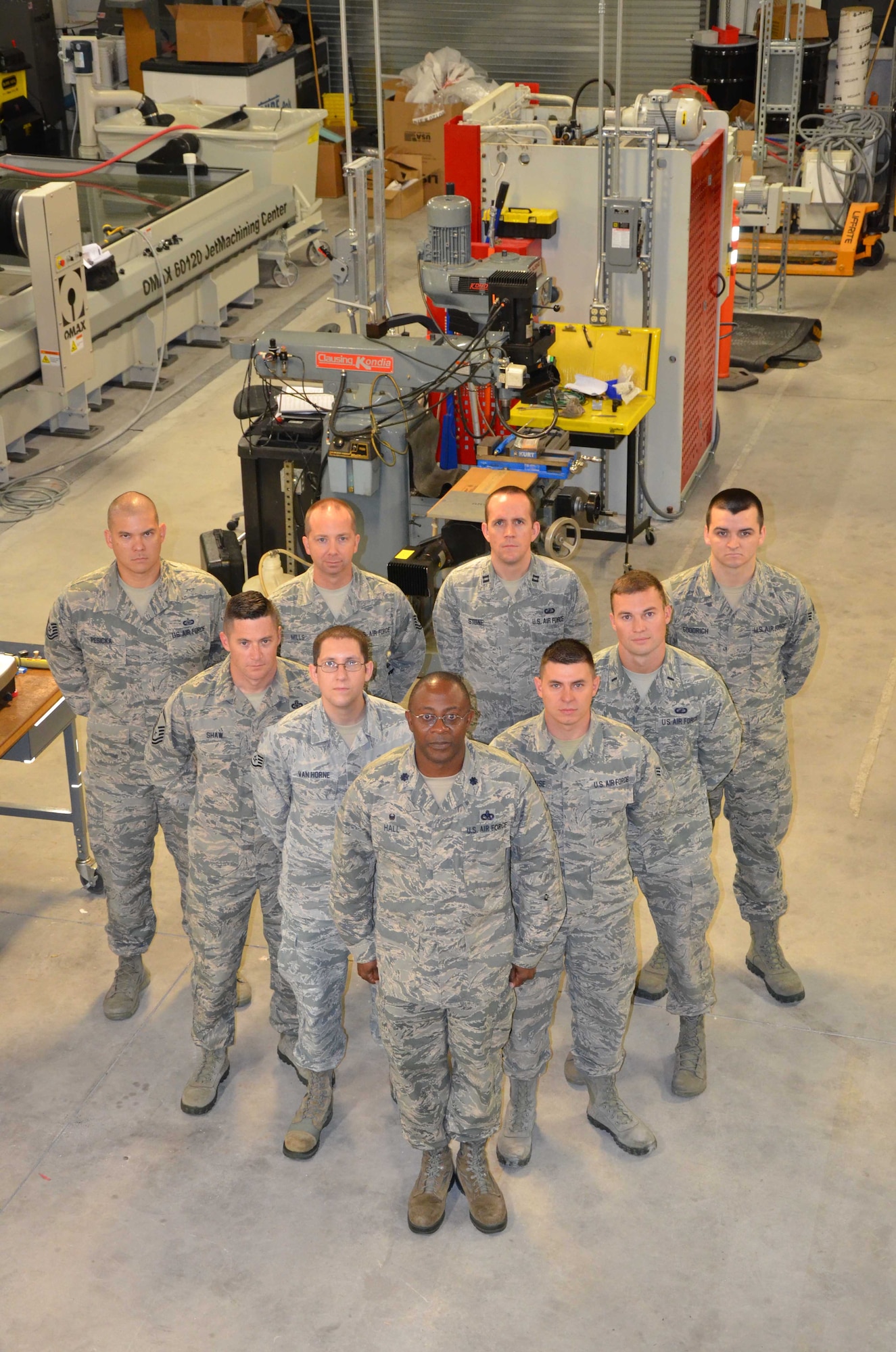 Members of the Air Force Technical Application Center's Innovation Lab pose in the nuclear treaty monitoring center's machine shop.  The lab encourages and enables innovators at AFTAC to take calculated risks and evolve from failure to achieve success.  Pictured (l to r starting in front row): Lt. Col. Christopher Hall, Staff Sgt. Josh Van Horne, Senior Airman James Rensehhouse, Master Sgt. Nathan Shaw, 1st Lt. Drew Belk, Tech. Sgt. Collin Pesicka, Tech. Sgt. Riley Mills, Capt. Barron Stone, and Senior Airman Matthew Goodrich.  (U.S. Air Force photo by Susan A. Romano)