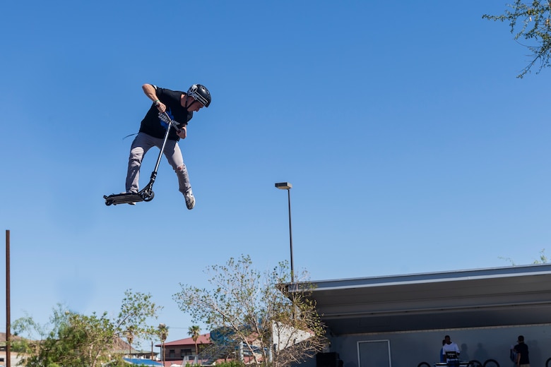 Bransyn Smith, professional Razor Scooter rider and X-Games athlete, performs a tail whip off of a box jump during the X-Games Action Sports Show at the Marine Corps Exchange parking lot aboard the Marine Corps Air Ground Combat Center, Twentynine Palms, Calif., Sept. 8, 2018. The X-Games provided a social recreational event in honor of the continuous service and sacrifice military personnel and family members make for the country. (U.S. Marine Corps photo by Pfc. Robin Lewis)