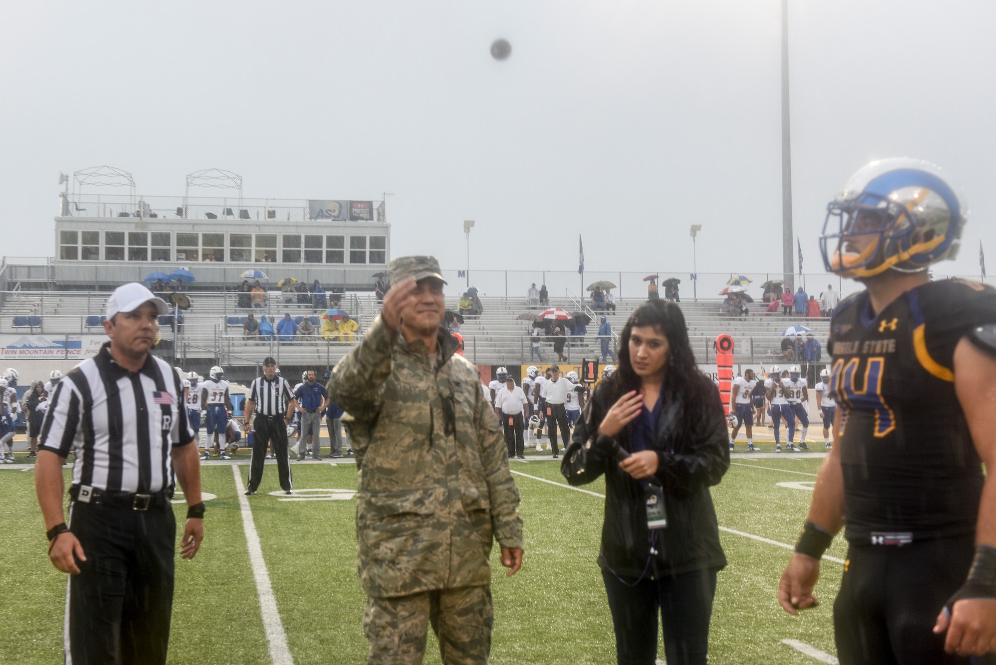 U.S. Air Force Col. Ricky Mills, 17th Training Wing commander, flips the coin to start the Angelo State University game against Texas A&M Kingsville during the Military Appreciation Day, at the LeGrand stadium, in San Angelo, Texas, Sept. 15, 2018. Texas A&M Kingsville won the toss, calling tails before the coin hit the ground. (U.S. Air Force photo by Aryn Lockhart/Released)