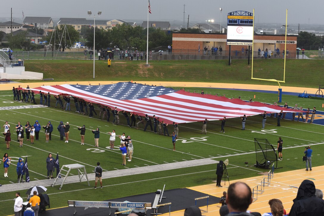 Angelo State University ROTC students unfold the American flag during the opening ceremonies of the Military Appreciation Day at LeGrand Stadium in San Angelo, Texas, Sept. 15, 2018. Along with the ceremonial unfolding of the flag, the ROTC students also celebrated each touchdown with a run to the end zone and pushups. (U.S. Air Force photo by Airman Zachary Chapman)