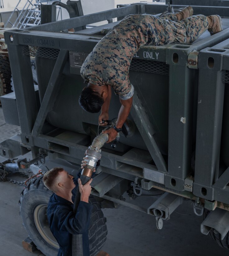 Marines with H&S Company, 1st Tank Battalion, work together to refuel a fuel tank on the 1st Tank Battalion ramp aboard the Marine Corps Air Ground Combat Center, Twentynine Palms Calif., August 29, 2018. Motor Transport Marines with 1st Tank Battalion increased overall readiness by 20% in the past three weeks by working extended hours. (Photo by Lance Cpl. Carley Vedro)