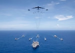 PHILIPPINE SEA (Sept. 17, 2018) USS Ronald Reagan (CVN 76) leads a formation of Carrier Strike Group Five ships as U.S. Air Force B-52 Stratofortress aircraft and U.S. Navy F/A-18s pass overhead for a photo exercise during Valiant Shield 2018. The biennial, U.S. only, field-training exercise focuses on integration of joint training among the U.S. Navy, Air Force and Marine Corps.
