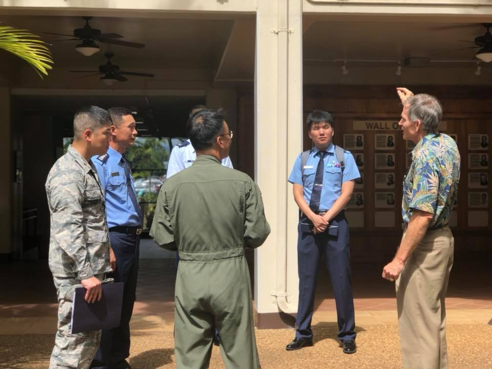 Charles Nicholls, Pacific Air Forces Historian briefs a group of Republic of Korea Air Force  Public Affairs Officers on the air strikes of Dec. 7, 1941 in the Courtyard of Heros at Joint Base Peral Harbor-Hickam, Hawaii on Sept. 11, 2018. ROKAF officers visited PACAF/PA who facilitaed dialogue on the importance of communicating in an integrated, synchronized, and purposeful way to build a united PA system capable of achieving common operational goals in case of emergencies and bilateral operations.  (U.S. Air Force photo by Master Sgt. Nadine Y. Barclay)