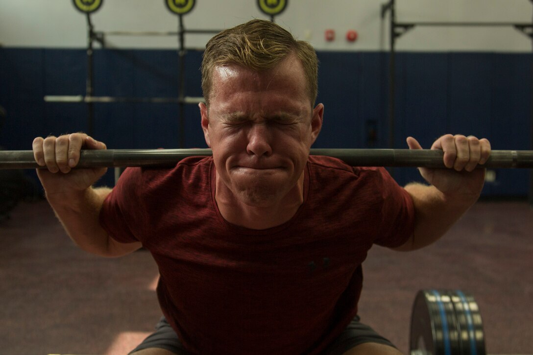 U.S. Marine Corps Maj. Michael Lowery, an F-18 pilot with Marine All Weather Fighter Attack Squadron (VMFA) 533, performs weighted squats at Marine Corps Air Station Iwakuni, Japan, Sep. 7, 2018. Lowery has maintained a perfect PFT and CFT for 12 years. (U.S. Marine Corps photo by Lance Cpl. Tyler Harmon)