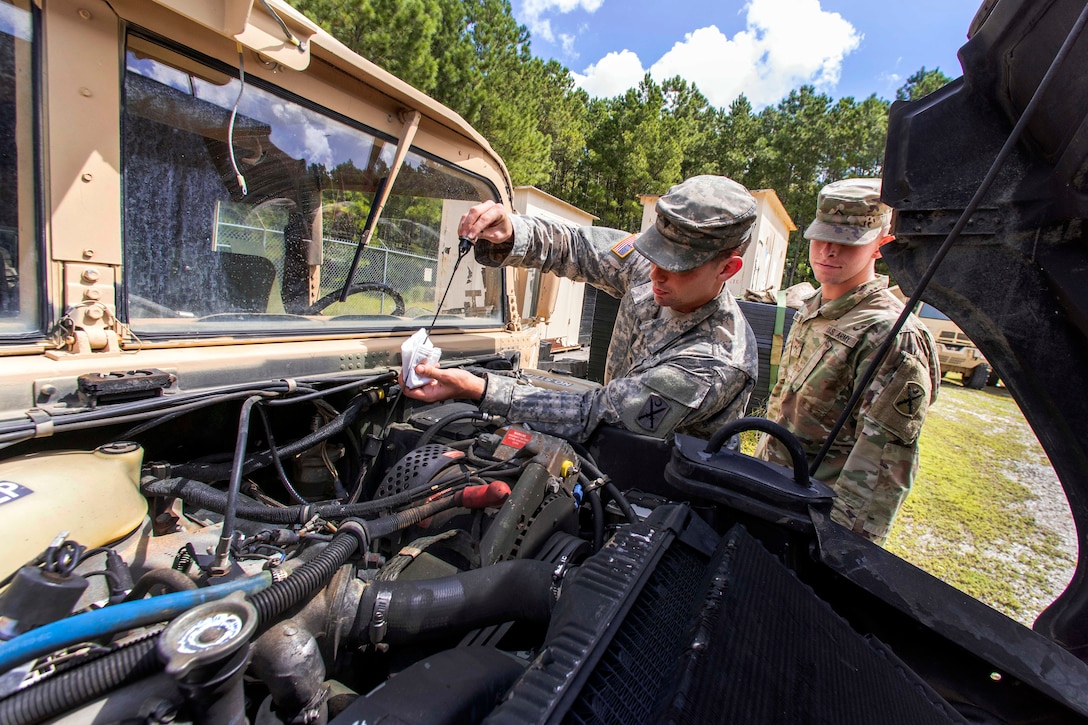 Soldiers perform preventative maintenance checks to unit vehicles.