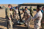 U.S. and Australian army instructors show an Iraqi soldier an M120 mortar system.