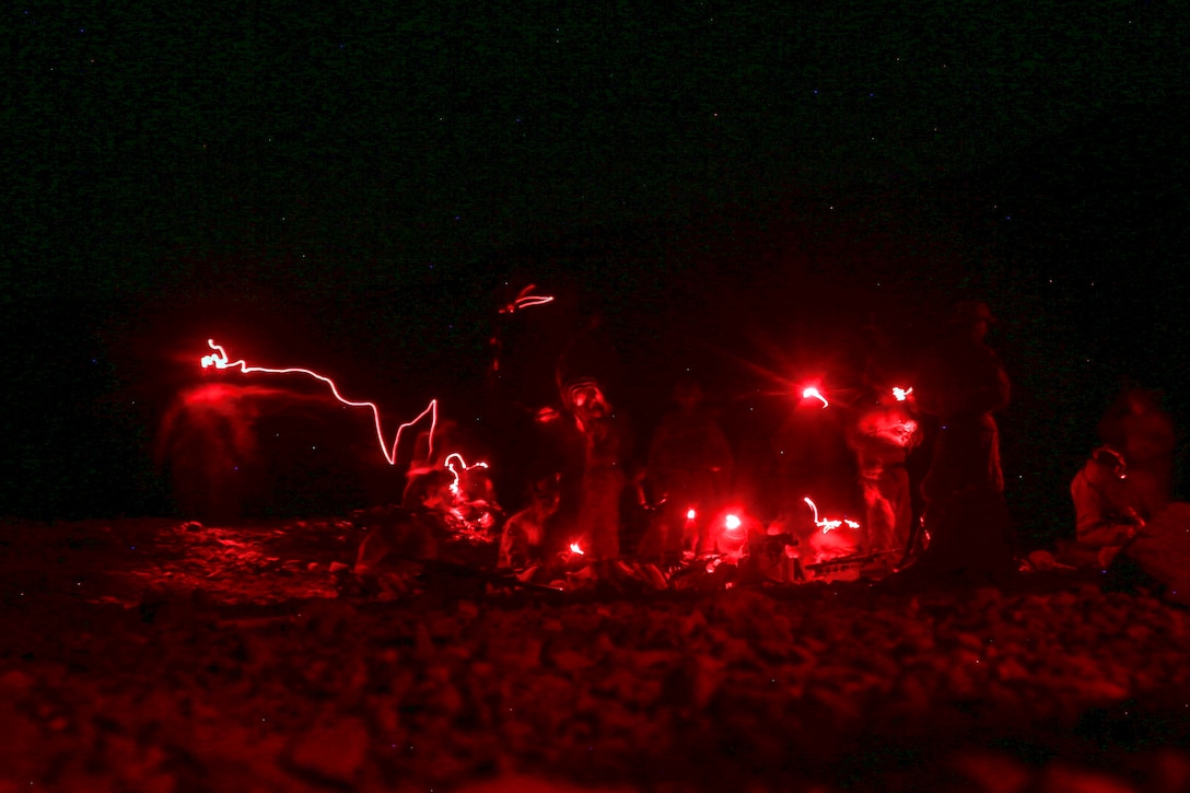 Marines load ammunition into magazines for a night live-fire exercise.