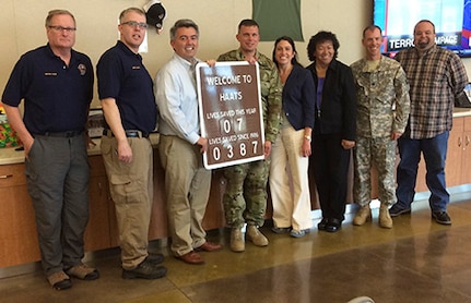 ​U.S. Senator Cory Gardner, third from left, holds the lives saved sign on display at the High-altitude Army National Guard Aviation Training Site in Gypsum, Colo., July 22, 2016. HAATS aircrews provide ground crews hoist capabilities in some of the most unforgiving terrain on earth. Additionally, HAATS aircraft and equipment, such as night vision googles, and extensive crew training allow rescue teams to reach terrain most civilian aircraft cannot. (Photo by defense contractor Michael Hillwig)