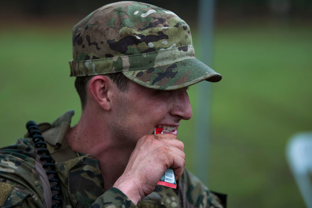 Senior Airman Jeffrey Lewis, 822d Base Defense Squadron fireteam lead, rips open a packet during the 2018 Defender Challenge, Sept. 11, at Joint Base San Antonio-Camp Bullis, Texas. Teams representing all twelve Air Force major commands, the Royal Air Force Regiment and German Air Force participated in the friendly competition, which tested their capabilities in dismounted operations, combat endurance and weapons tactics. The Air Combat Command team won second place in the overall competition, combat endurance and weapons challenge. (U.S. Air Force photo by Airman Taryn Butler)