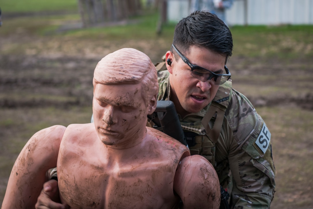 Staff Sgt. Paul Rosales, 55th Security Forces Squadron combat arms instructor, lifts a simulated victim into the back of a humvee during the 2018 Defender Challenge, Sept. 12, at Joint Base San Antonio-Camp Bullis, Texas. Teams representing all twelve Air Force major commands, the Royal Air Force Regiment and German Air Force participated in the friendly competition, which tested their capabilities in dismounted operations, combat endurance and weapons tactics. The Air Combat Command team won second place in the overall competition, combat endurance and weapons challenge. (U.S. Air Force photo by Airman Taryn Butler)