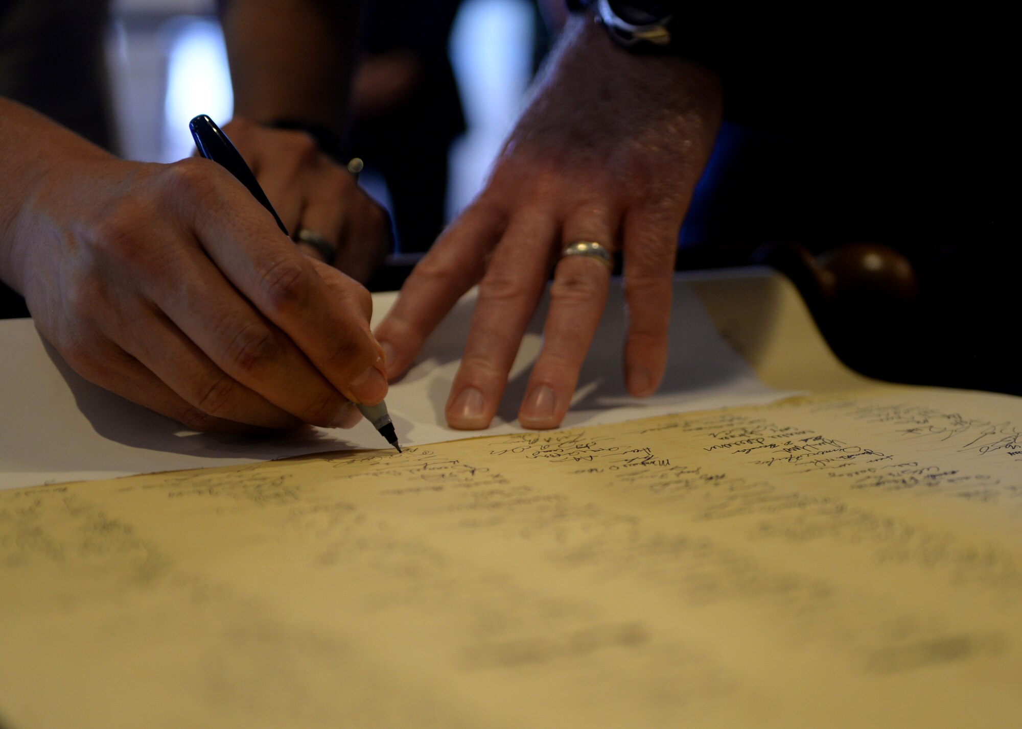 Enlisted Airmen sign a scroll in honor of retired Lt. Gen. Darryl Roberson prior to an Order of the Sword Ceremony at Luke Air Force Base, Ariz., Sept. 13, 2018.