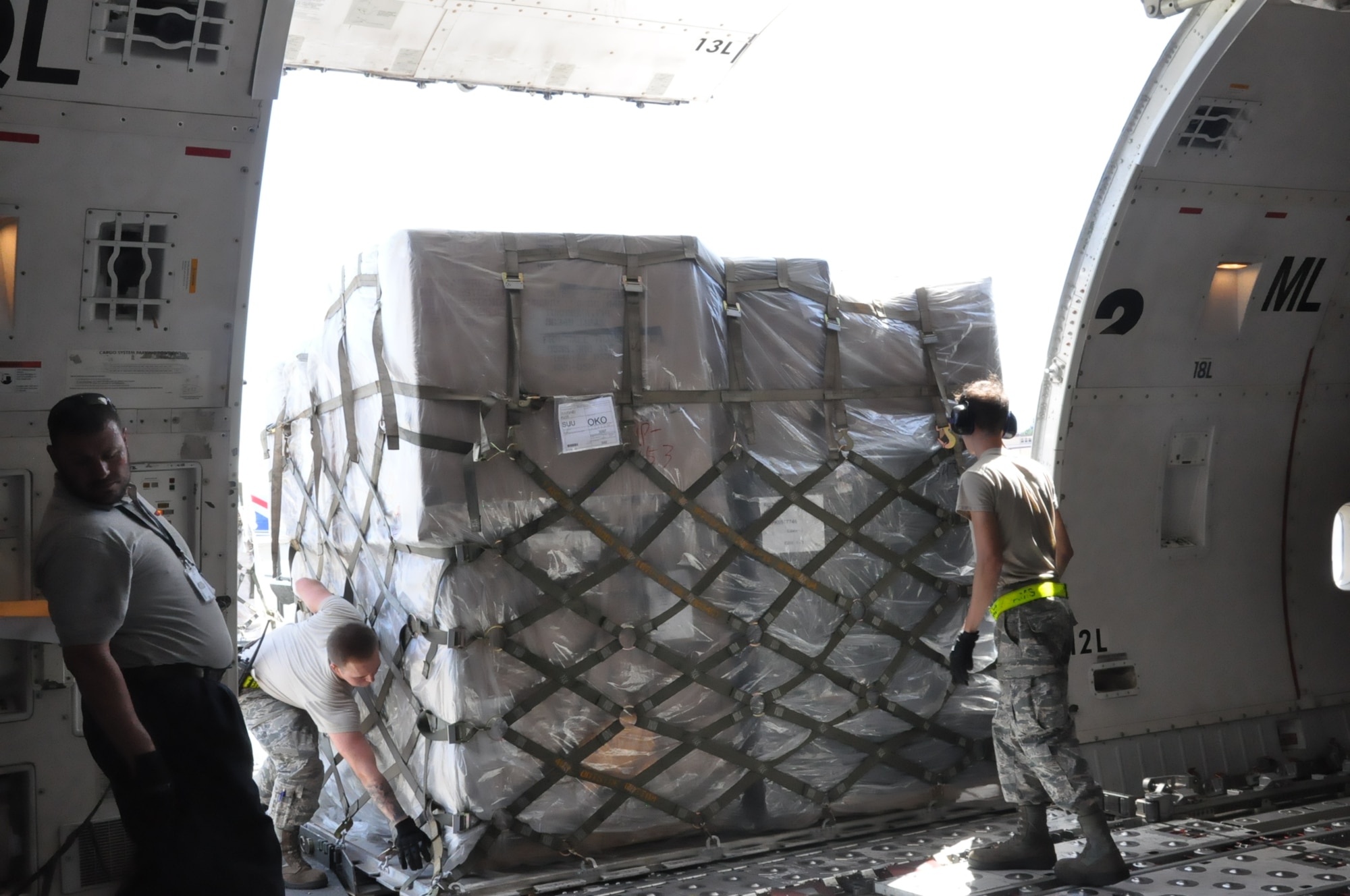 Airmen 1st Class Ryan Adams and Cody Lumley, air freight technicians from the 730th Air Mobility Squadron offload cargo at Yokota Air Base, Japan before the aircraft continues onto Paya Lebar Air Base in Singapore, 22 Aug. 2018. Air Mobility Command sustains 42 en-route locations around the globe through the use of a complex system of channels. These channels enable transport of personnel and worldwide cargo from location to location to sustain the joint warfighter.