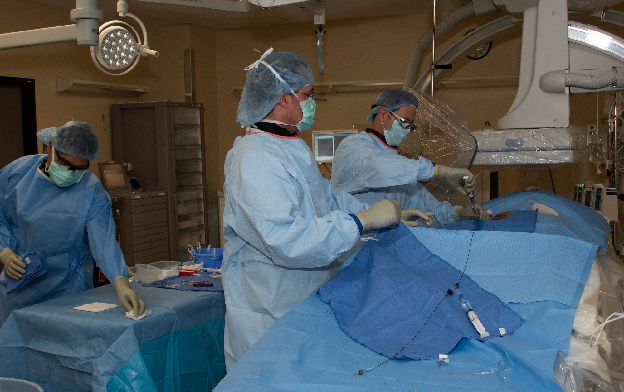 U.S. Air Force Lt. Col. (Dr.) David Gover and Maj. (Dr.) Jason Hoskins, 60th Medical Group interventional radiologists at David Grant USAF Medical Center conduct a Yttrium-90 radioembolization procedure for a patient with liver cancer Sept. 7, 2018 at Travis Air Force Base, Calif. The procedure is an advanced and minimally invasive method utilized to treat cancer by delivering millions of tiny radioactive beads inside the blood vessels that feed a tumor. The high dose of targeted radiation prospectively kills the tumor while sparing normal tissue. This was the first time the treatment was performed at DGMC. (U.S. Air Force Photo by Heide Couch)