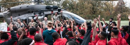 Capt. Demetria Elosiebo stands on an aircraft while she engages students from the KIPP DC sixth-grade class. In 2014, Elosiebo made history by becoming the DCNG's first female African-American pilot. (U.S. Army National Guard photo by Staff Sgt. Aimee Fujikawa/Released)