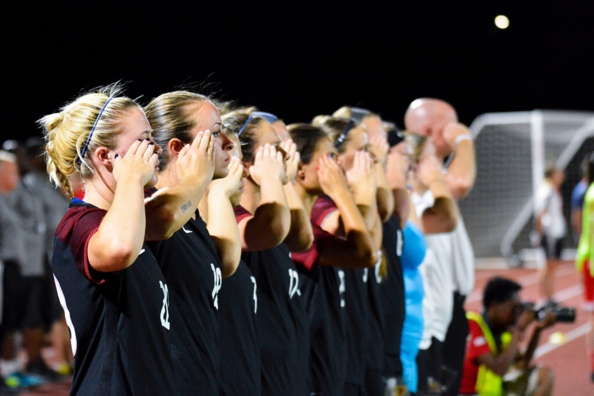 1st Lt. Carla Cimo, forward, U.S. Women’s National Armed Forces Soccer team and teammates salute the United States Flag during the playing of the U.S. National Anthem before a game. Anthems for both countries are played as part of pre-game ceremonies. (Courtesy photo)